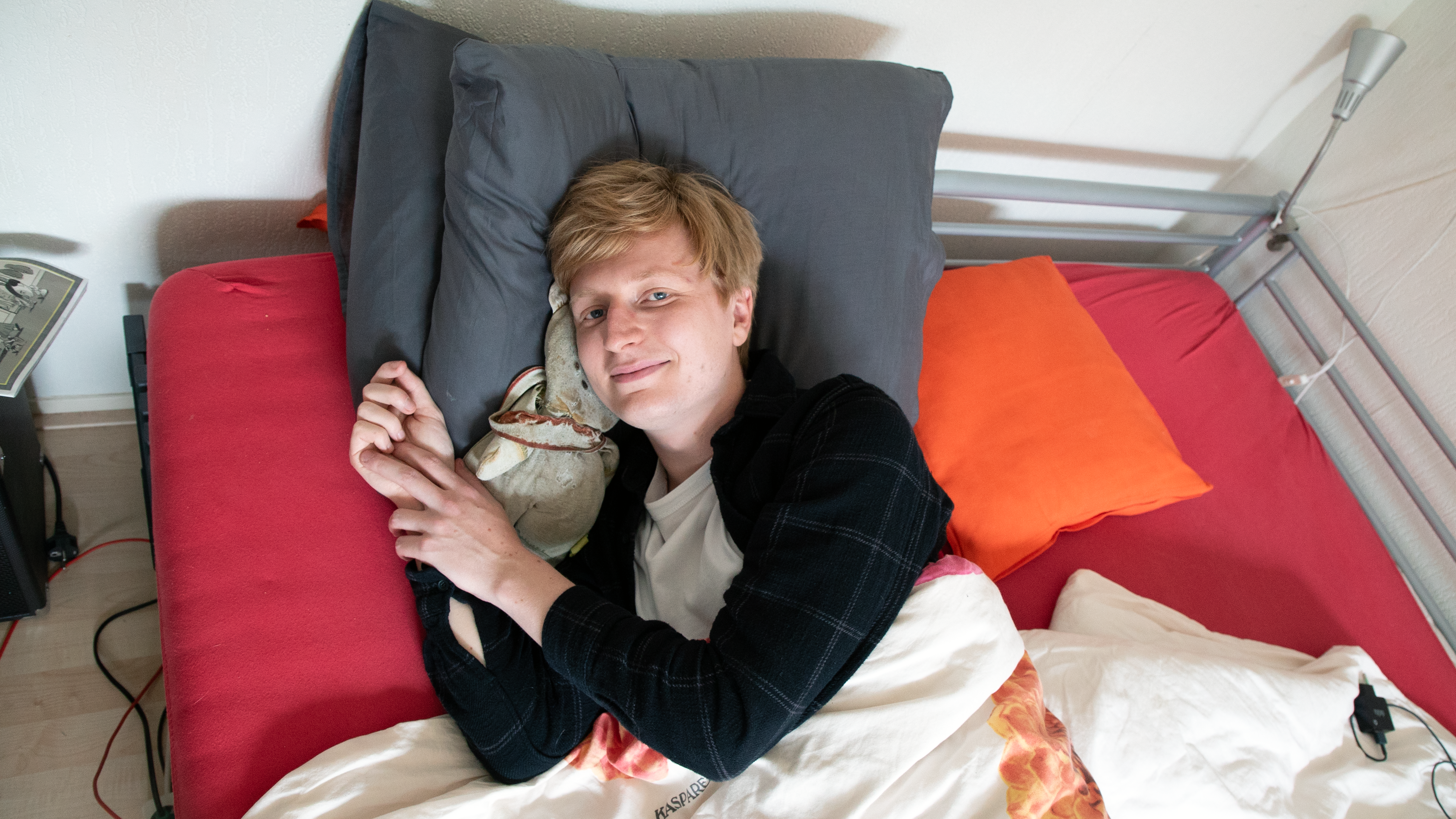 mik ligt in bed met knuffel onder zijn hoofd