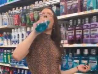 Vrouw gorgelt in supermarkt met mondwater en spuugt het terug uit