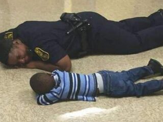 Agente gaat naast verdrietig jongetje liggen om hem te troosten