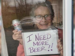 Oma met 'I Need More Beer'-bord krijgt 150 blikjes op de stoep geleverd