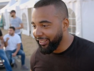 Mula B probeert op tv uit te leggen wat het woord 'kech' volgens hem betekent