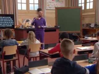 Ronnie Flex legt zijn rapteksten uit aan kinderen in de klas