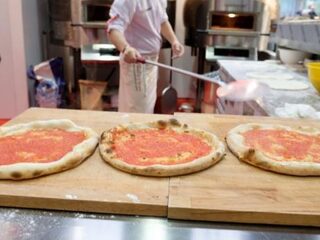 Pizzeria hangt opgezette koe boven etende klanten