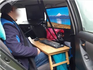 Man is thuiswerken zat en bouwt auto om tot kantoor