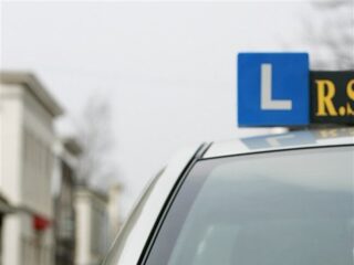 Foutje met het gas- en rempedaal: lesauto belandt bovenop geparkeerde auto