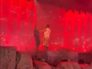 Travis Scott grijpt fan vast nadat deze podium op rent tijdens concert
