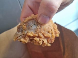 Vrouw vindt hele kippenkop in haar KFC-bucket