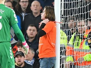 Demonstrant bindt zich vast aan doelpaal tijdens Premier League-duel