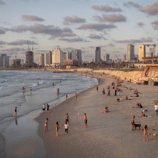 Strandtas en vluchtkoffer staan naast elkaar in Libanon terwijl Israëlische straaljagers overvliegen