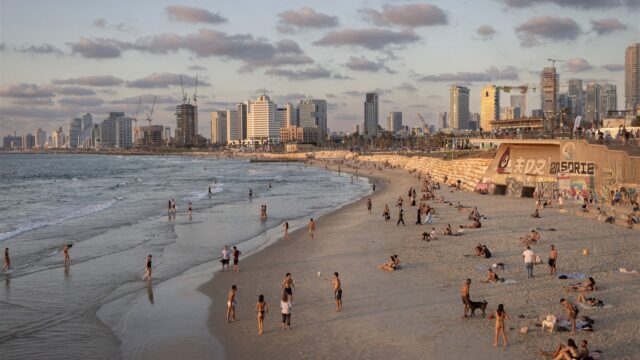 Strandtas en vluchtkoffer staan naast elkaar in Libanon terwijl Israëlische straaljagers overvliegen