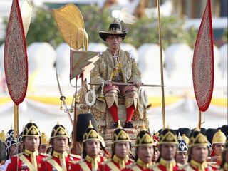 Nieuwe Thaise koning op gouden stoel door Bangkok gedragen