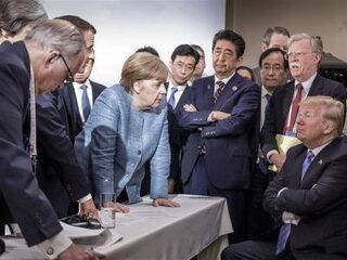 De apenrots van de G7: 'De houding van Merkel is bijna letterlijk die van een chimpansee'