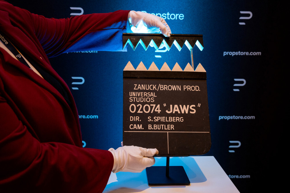 A staff member holds a Jaws Clapperboard during a press preview of movie props set to go to auction, in London on August 6, 2025. The auction is set to go ahead in September 2025 in Los Angeles.