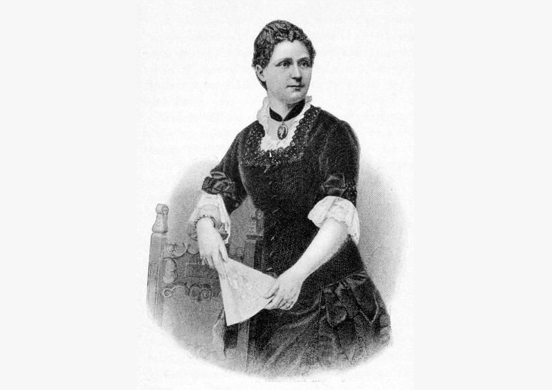 Een zwart-wit afbeelding van een vrouw met een zwarte jurk met witte kraag. Ze kijkt opzij en heeft een waaier vast.