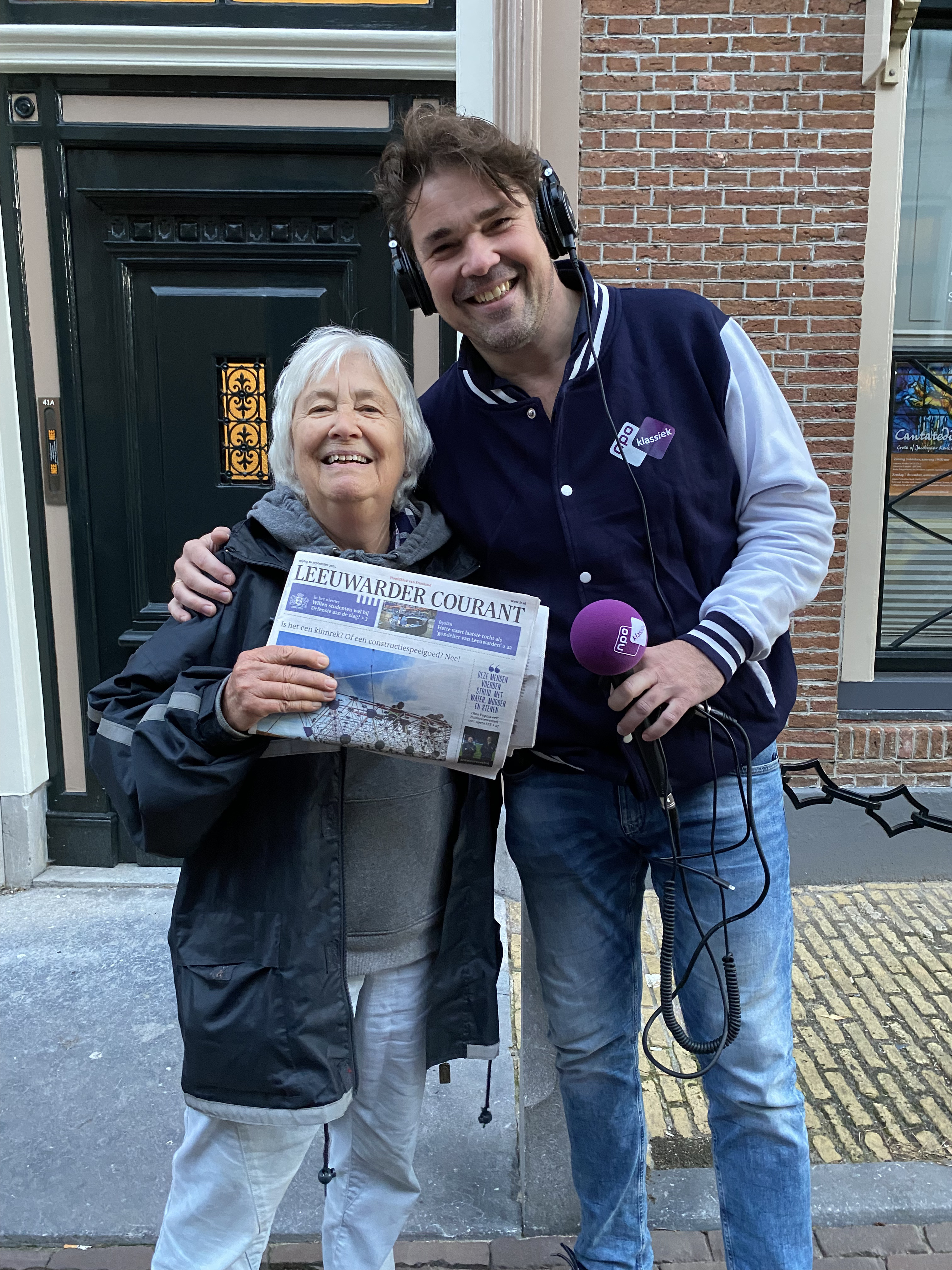 Ab Nieuwdorp met luisteraar Auk, die de krant van haar krantenwijk omhoog houdt