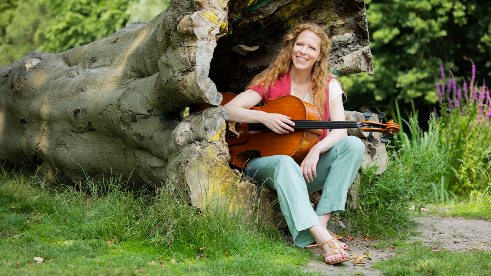 Irene Kok met haar cello in het bos