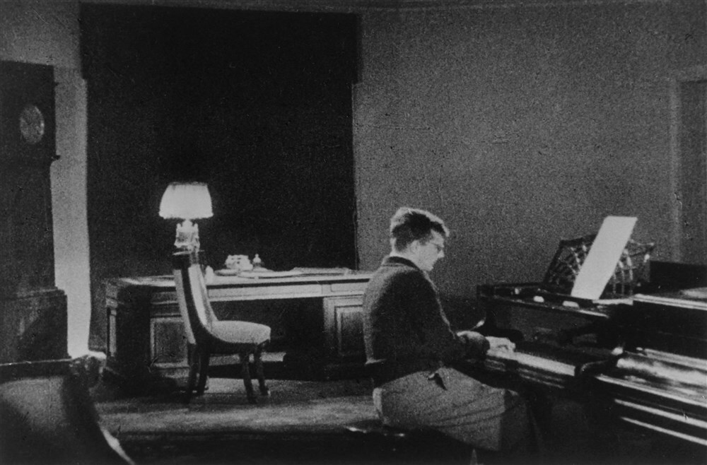 Dmitri Sjostakovitsj aan de piano in 1941 terwijl hij zijn Zevende symfonie componeert