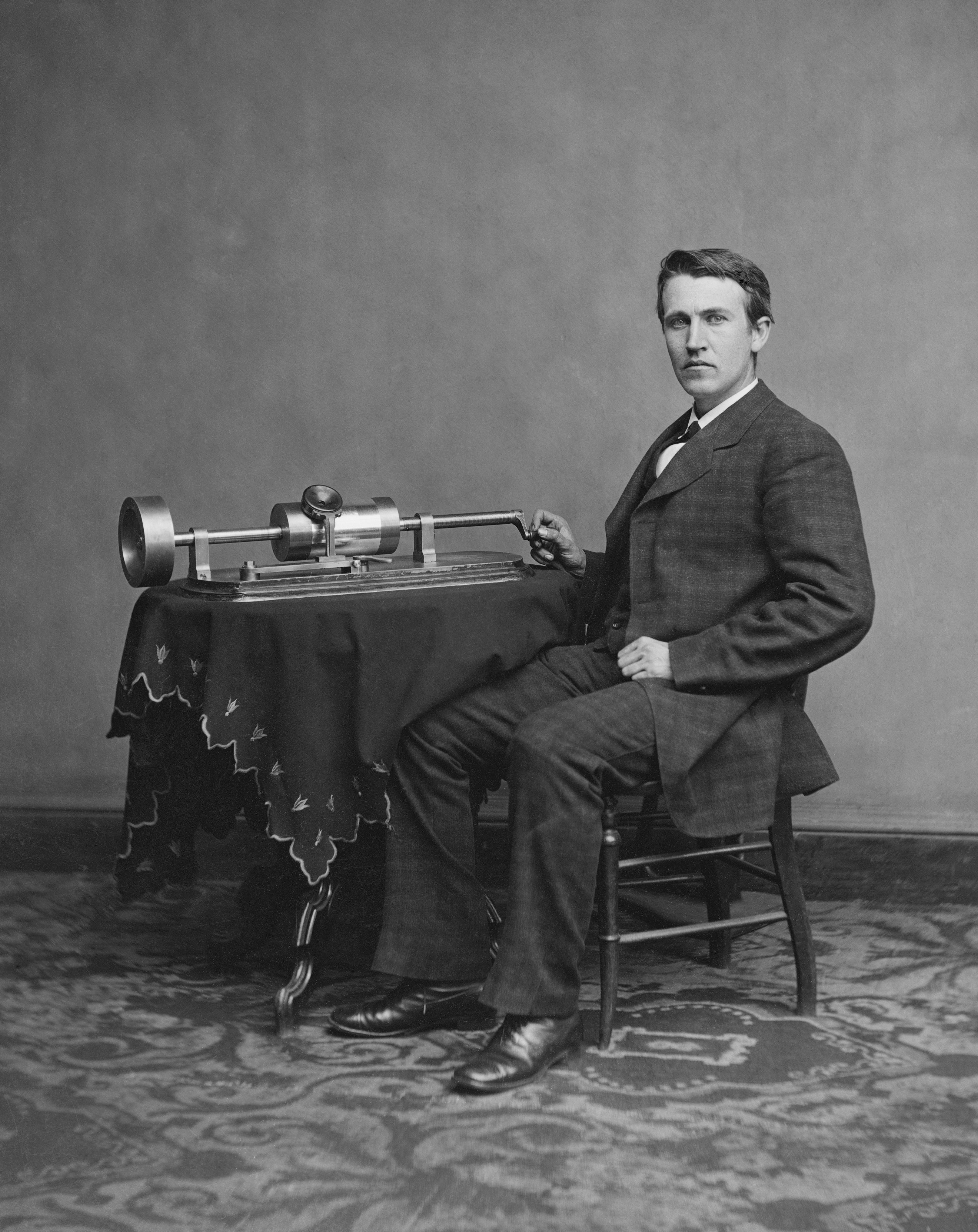 Een foto van de uitvinder Edison, zittend naast de door hem uitgevonden fonograaf