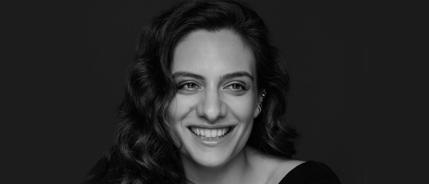 Een zwart-witfoto van een lachende Aftab Darvishi